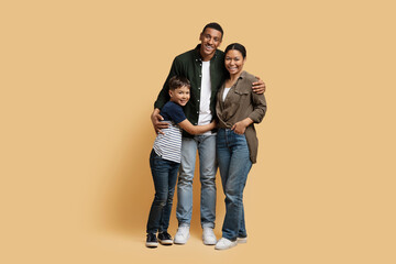 Beautiful black family posing together isolated on beige background