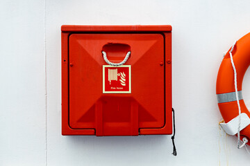 red fire hose stowage against a white background