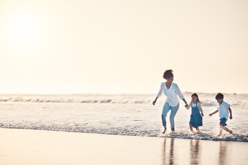 Playing, mother and children at beach on a fun family vacation, holiday or nature adventure at sunset. Young boy and girl holding hands with a woman outdoor for fun energy, happiness and banner space - Powered by Adobe