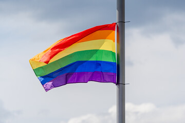 Celebration of pride month, Colourful rainbow flag hanging waving in the air on white grey background, Symbol of Gay, Lesbian, Bisexual and Transgender, LGBTQ community, Worldwide social movements.