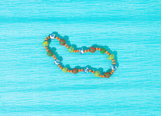 Colorful necklace on turquoise blue background. Close up view. Minimal concept of jewelry. Copy space. Flat lay.
