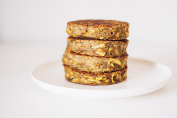 Delicious freshly cooked gluten free thick zucchini pancakes made with natural ingridients such as banana flour, eggs and summer squash. Healthy food with no gluten. Shallow depth of field.