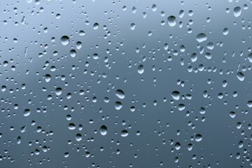 Rain drops on the surface of a window glass in a rainy day