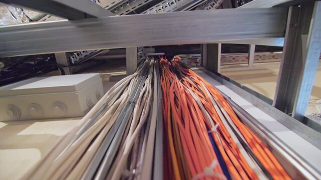 Freshly mounted wires of different colours bounded with plastic strips. Replacing wiring in redecorated premise in public building