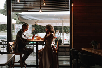 Side view portrait of a laughing European couple enjoying a date in a cafe. A couple in love, a man...