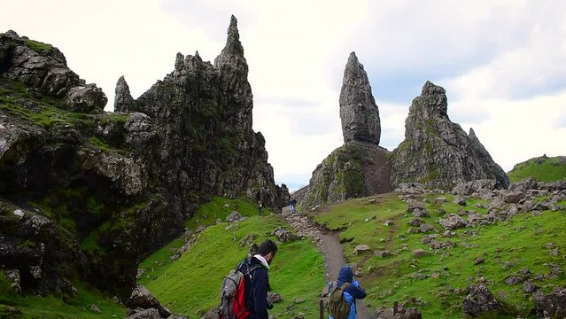 Active people walking the Old Man of Storr hiking trail. Popular landmark on Isle of Skye, Scotland