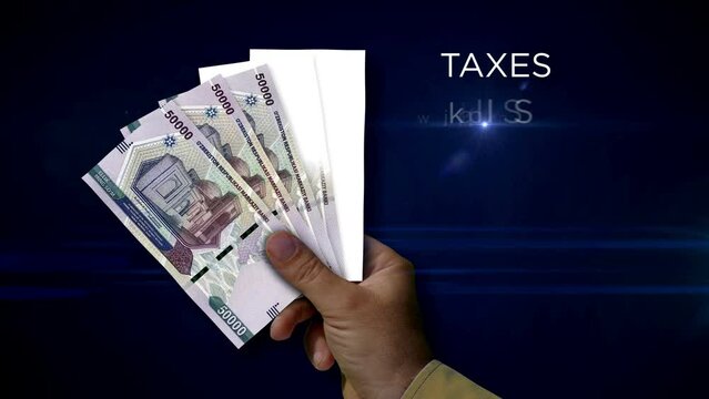 Uzbekistan Sum paper note holding. Fan of UZS banknotes in hand. Metaphor concept of income loss, cost of live, tax, credits and money decline.