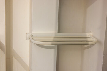 Close-up view of white swimwear drying rack at hotel room balcony. 