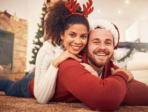 Christmas, portrait and happy couple in home on floor, bonding and together. Xmas, smile and face of man with African woman, interracial and enjoying time for party, celebration and winter holiday - Powered by Adobe