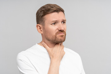 Fototapeta premium Throat pain. Sick guy with aching sore throat suffer from tonsillitis angina. Unhealthy man touch neck feeling discomfort and pain swallowing. Infection disease, seasonal flu or voice loss, isolated. 