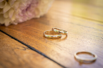colorful mug of coffee on wooden surface with engagement rings and ring, concept of engagement,...