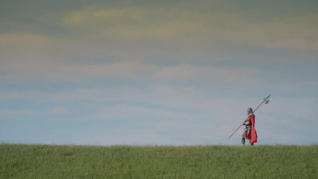 Roman soldier guarding a green field at boundary. Slow motion