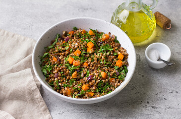 Buckwheat with vegetables and kale on a gray textured background, top view. Delicious healthy vegan food