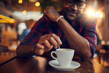 Fototapeta na wymiar Young man enjoying coffee at a cafe