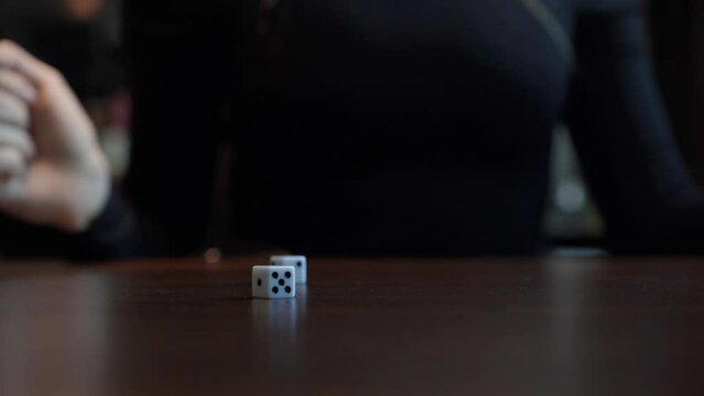 Play dice game. Concept of Gambling, the Concept of Entertainment Games, Hand of Woman Throwing Dice against Black, Hand rolls dice for the game. Gambling luck concept: risk, have luck, win, lucky