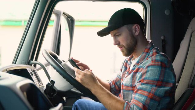 Professional trucker using truck gps navigation to transport and deliver goods to the destination. Transportation services. Right hand drive car