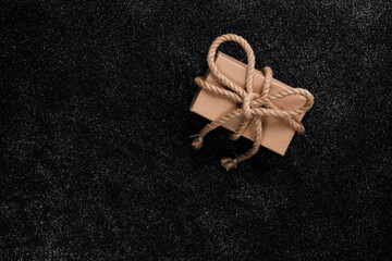 A box with a gift for a man on a black table,  from above.