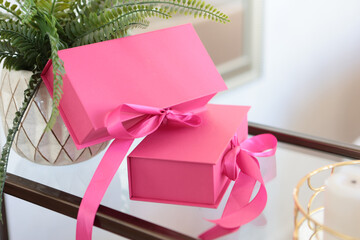 Pink gift boxes with ribbons. The boxes are on the shelf. Gifts in boxes for the holiday.Copy space.