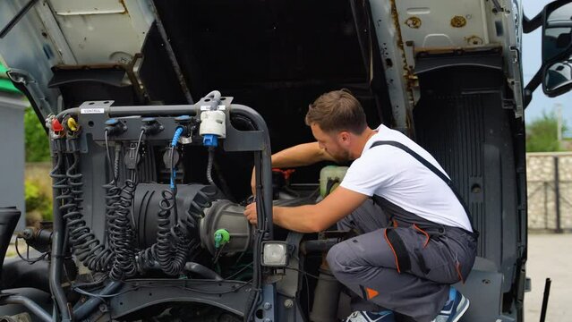 Mechanic repairing the truck. Diesel Engine Truck. Auto Service Shop