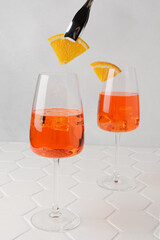 Aperol spritz cold summer cocktail with aperitif, prosecco, ice and slice of orange in a glass on...