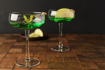 Classik Apple martini - appletini, cold summer cocktail with gin, apple liqueur, dry vermouth and ice on the black background. Copy space for text