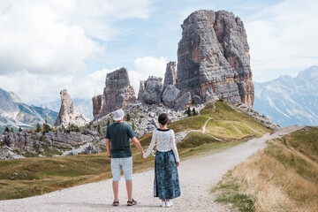 Beautiful traveler couple in front of the iconic Dolomites - Cinque Torry