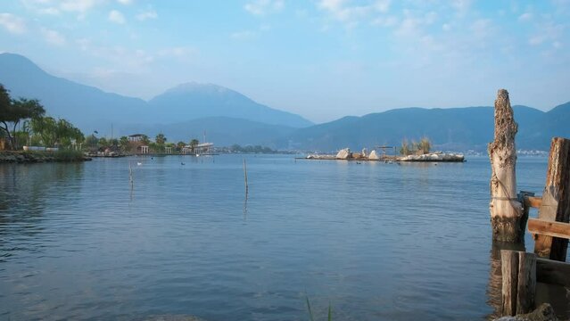 Calm lake with handmake pier. A nice handmake pier with moored fishing boat under warm summer sun. A concept of calm summer resting by water.