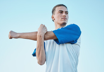 Naklejka premium Soccer, stretching and a sports man on a blue sky background in preparation for a game or competition. Fitness, health and warm up with a young male athlete getting ready for training or practice