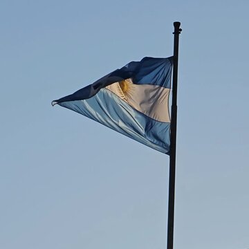 Bandera argentina flameando en el cielo azul. Cuadrado