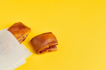 Lanche misto traditional portuguese sandwich with cheese and chorizo. Tasty breakfast over yellow background.