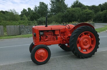 Old English tractor in the field in red.