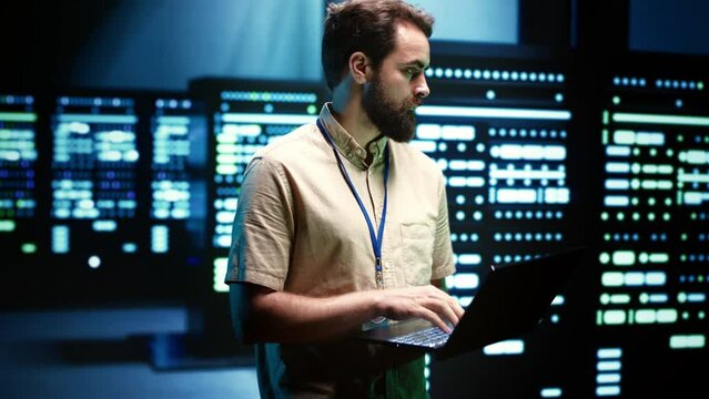 Close up of adept technician using laptop to check operational server hub. Hardware clusters in data storage and cloud computing business service providing processing for several workloads