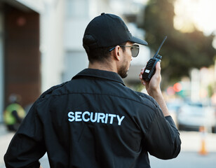 Radio, man and a security guard or safety officer outdoor on a city road for communication. Back of a person with a walkie talkie on urban street to report crime for investigation and surveillance - Powered by Adobe
