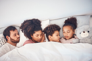Fototapeta premium Sleeping, above and family in a bed with love, dreaming and resting in their home cosy together. Sleep, top view and children with parents in a bedroom nap, peaceful and hugging, comfort and bond