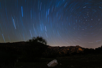 A view of the stars of the Milky Way with a mountain top in the foreground. Night sky nature summer...