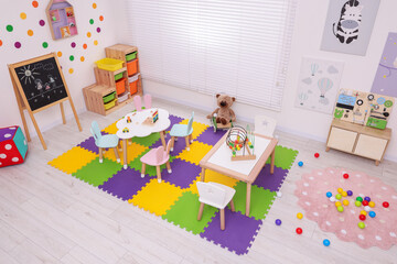 Stylish kindergarten interior with toys and modern furniture, above view