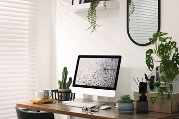 Cozy workspace with computer on wooden desk at home