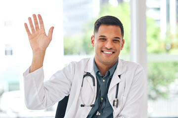 Doctor, portrait and wave with smile at desk for video call, telehealth service and hello for kindness. Young medic man, sign language and respect with introduction, happy and webinar for healthcare