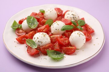 Tasty salad Caprese with tomatoes, mozzarella balls and basil on pink background, closeup