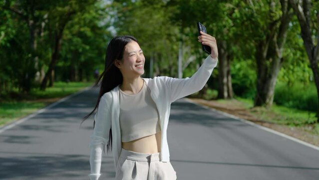 Travel concept of 4k Resolution. Asian woman taking pictures selfie and smile on road trip, vacation and happy for blog, profile picture and photography for social media