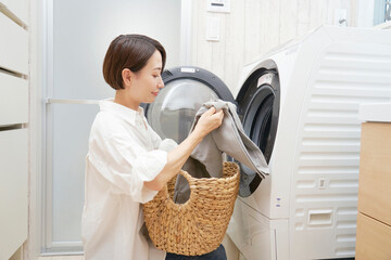 洗濯機から洗濯物を取り出すミドルエイジの女性