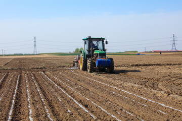 Obraz premium In spring, farmers use farm machinery to grow peanuts