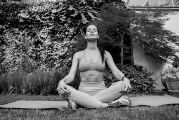 Black and white image f young woman meditating outdoors 