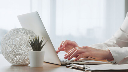 Working online. Computer project. Home office. Business woman hands tapping on laptop to complete...