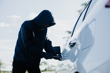Fototapeta na wymiar Close-up car thief hand holding screwdriver tamper yank and glove black. Man robber checking breaking entering alarm in a car stealing. Image about reflect society.