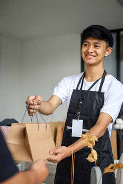 Shop Keeper Giving Shopping Bag To Customer