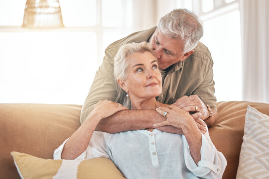 Old couple, hug and kiss with retirement together, love and care in marriage with people at home. Relax in living room, life partner and pension, man and woman bonding with trust and commitment
