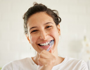 Healthcare, portrait of a woman brush her teeth and smile in her bathroom of her home. Hygiene or self care, health wellness or dental treatment and female person with brushing mouth with toothbrush