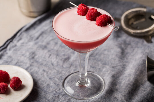 Alcoholic Clover Club cocktail pink gin, dry vermouth, raspberry sugar syrup, fresh lemon juice, fresh lime juice and egg white