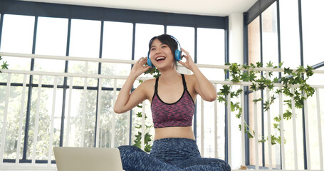 Happy beauty women dance on floor use headphone listen to music wellness lifestyle. Beautiful woman smile listen music. Yoga woman workout in sportswear sit on yoga mat home fitness workout exercise
